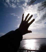 Ausgestreckte Hand vor Himmel und Wasser